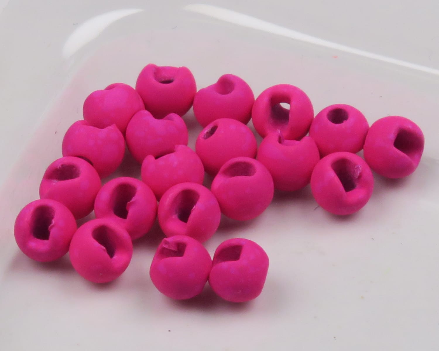 Bright magenta mottled tactical slotted tungsten beads with round matte finish and side slots for fly tying