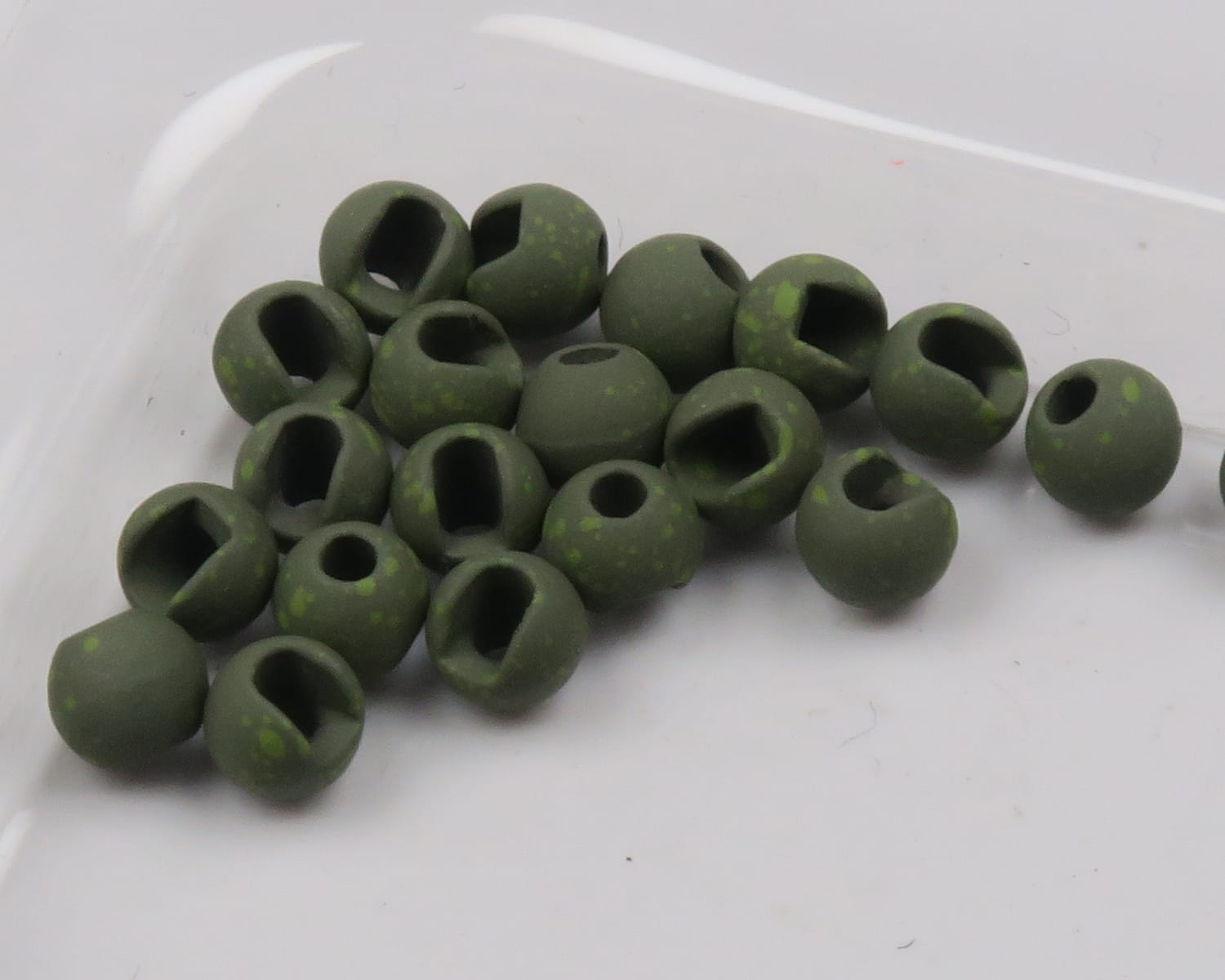 Mottled olive-green slotted tungsten beads with matte finish and speckled pattern for fly tying