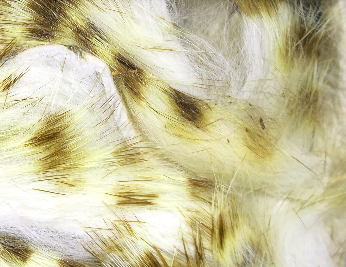 Olive-barred rabbit fur strips with white underfur and olive-yellow barred guard hairs, soft fly tying material