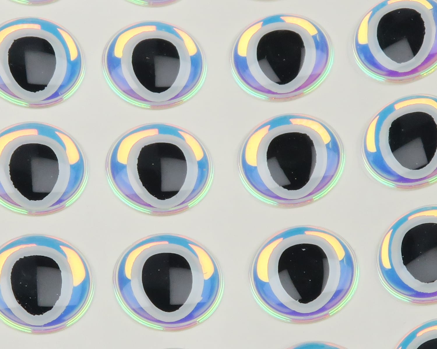 Hareline 3D oval pupil adhesive eyes: iridescent blue-white rings with black oval pupils on clear backing for fly tying