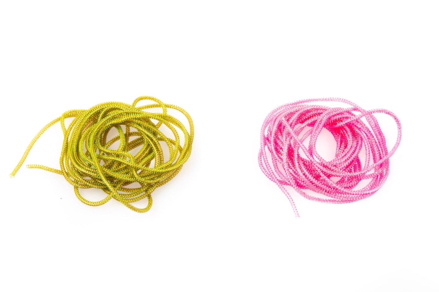 Two coiled Hareline pearl core braids, metallic chartreuse-green and hot pink, sparkly synthetic cord for fly tying.