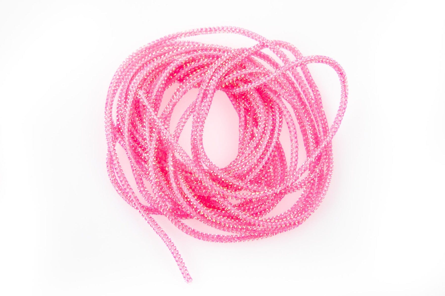 Coiled bright pink sparkly Pearl Core Braid cord for fly tying, braided tubular material with iridescent sheen