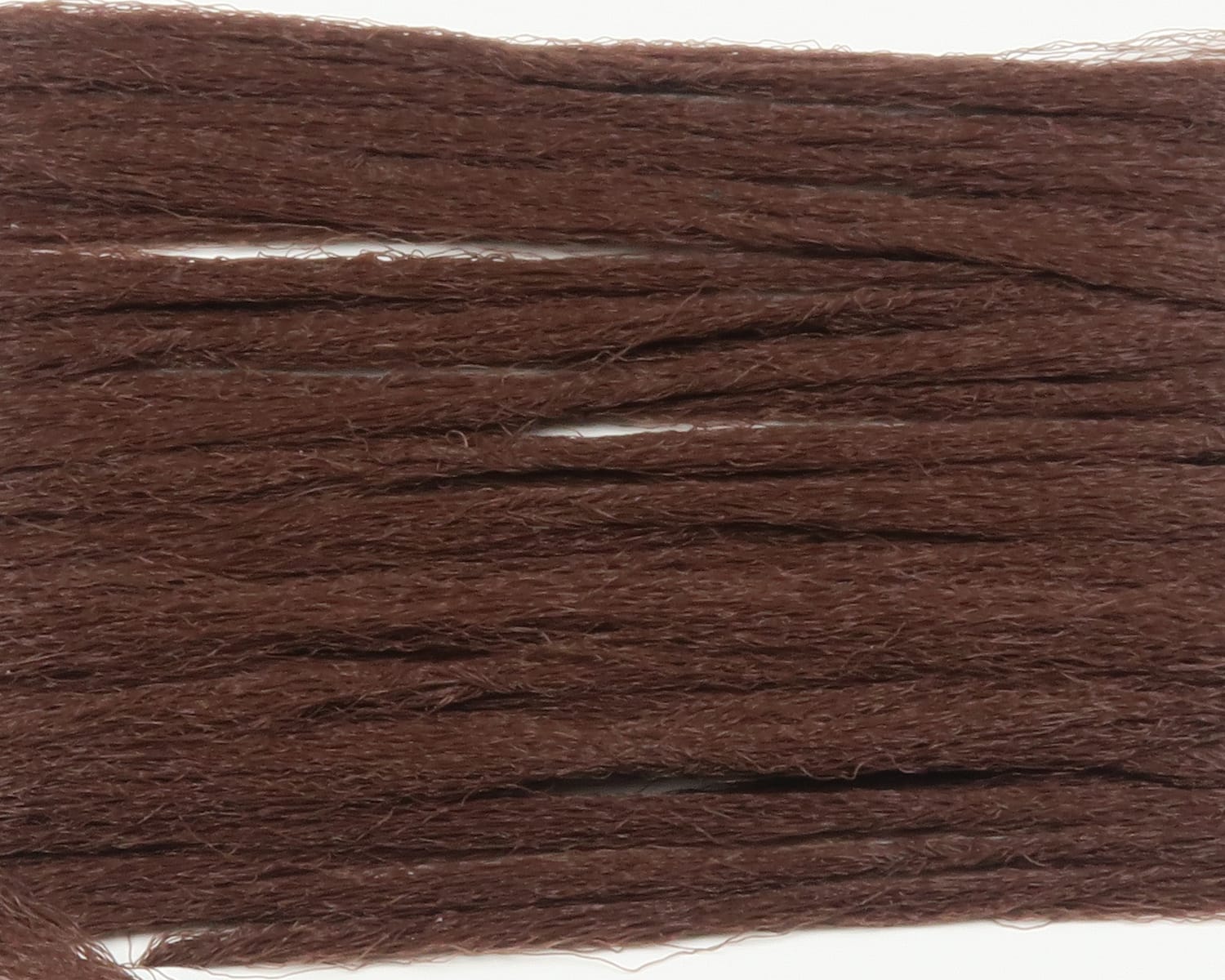 Hareline polypropylene floating yarn close-up showing bundled chocolate brown fibrous strands