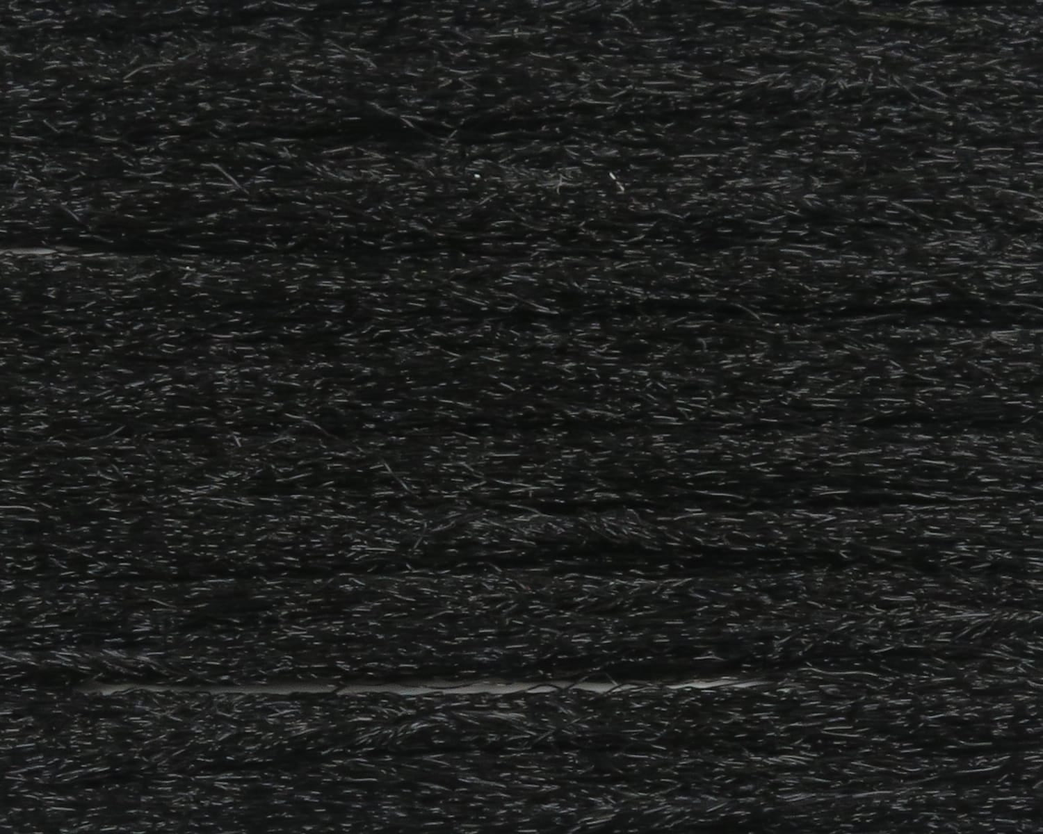 Black Hareline polypropylene floating yarn with shiny textured black strands aligned in parallel for fly tying