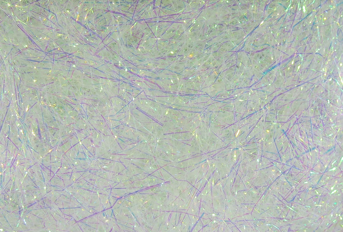 White iridescent synthetic Hareline Ice Dub dubbing with fine purple and green holographic fibers, sparkly fly tying material