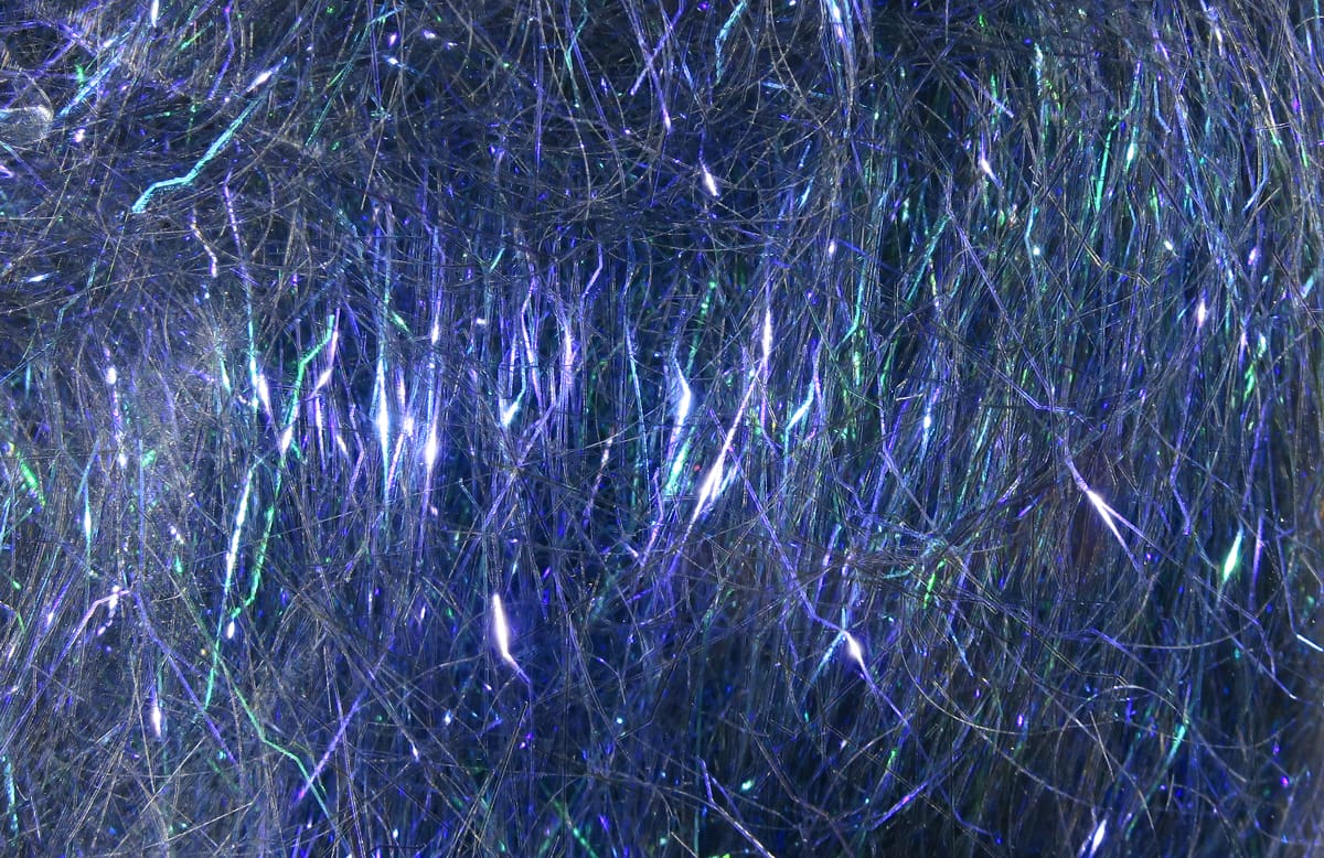 Iridescent blue-purple Hareline Ripple Ice Dub fibers with green flashes, fine shimmery fly tying dubbing material