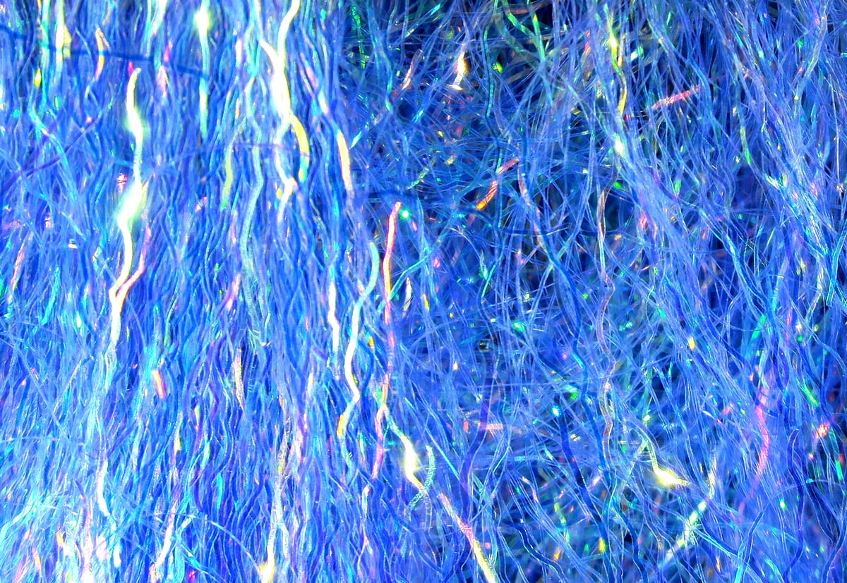 Iridescent blue Hareline Ripple Ice Fiber, wavy synthetic fly-tying strands with holographic flash