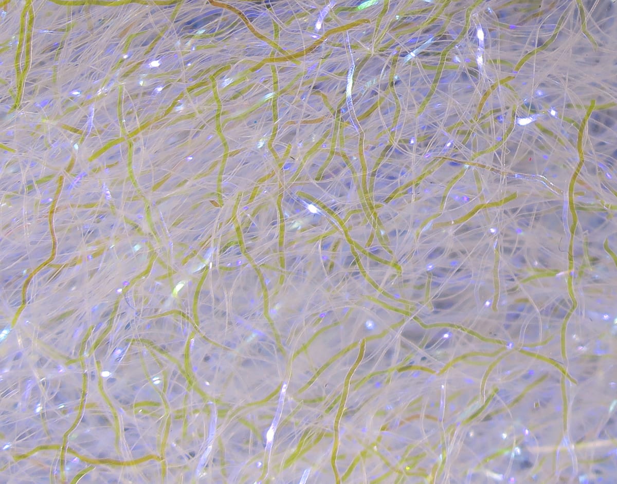 White translucent Hareline Ripple Ice Fiber with chartreuse wavy strands and iridescent sparkle for fly tying