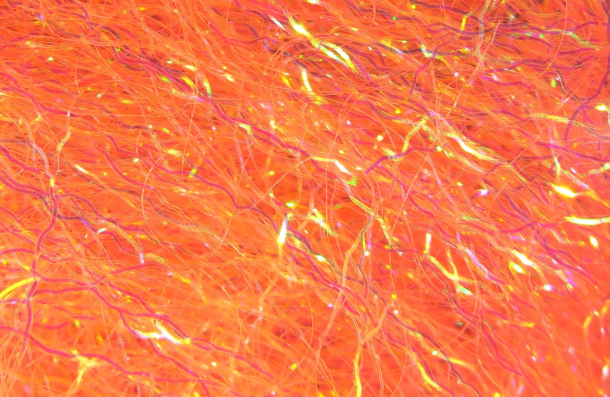 Vibrant orange Hareline Ripple Ice Fiber with iridescent wavy synthetic strands for fly tying
