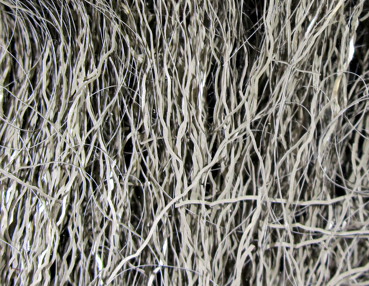 Hareline Ripple Ice Fiber for fly tying, close-up of wavy rippled metallic silver synthetic strands with shimmer