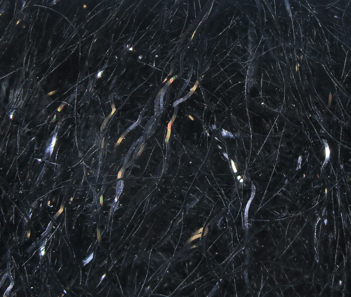 Black ripple ice fiber with fine synthetic strands and iridescent wavy flash, fly tying material