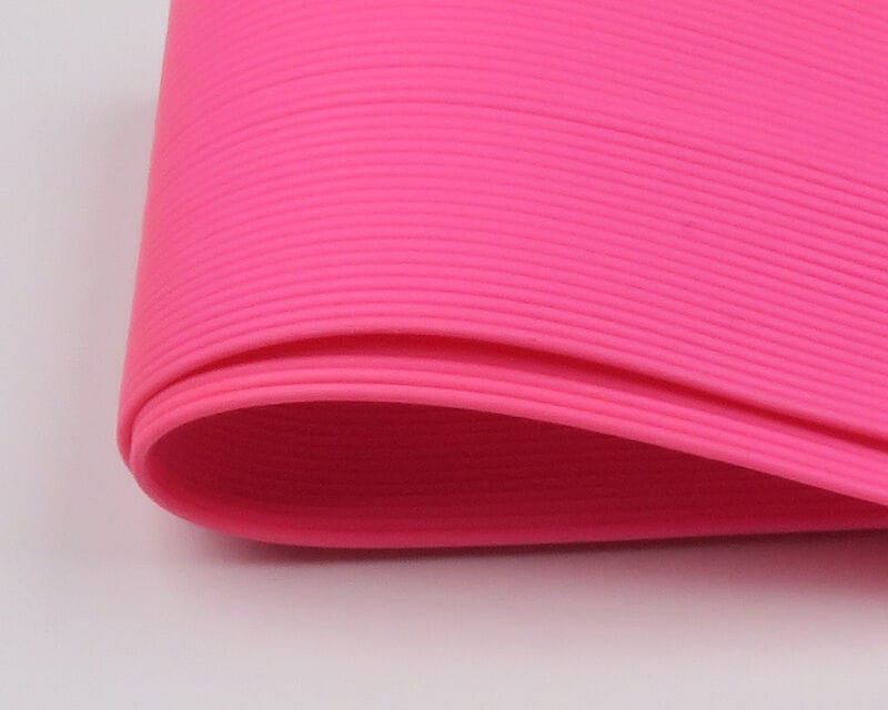 Hot pink Hareline round rubber legs roll showing ribbed, flexible rubber tubing texture for fly tying
