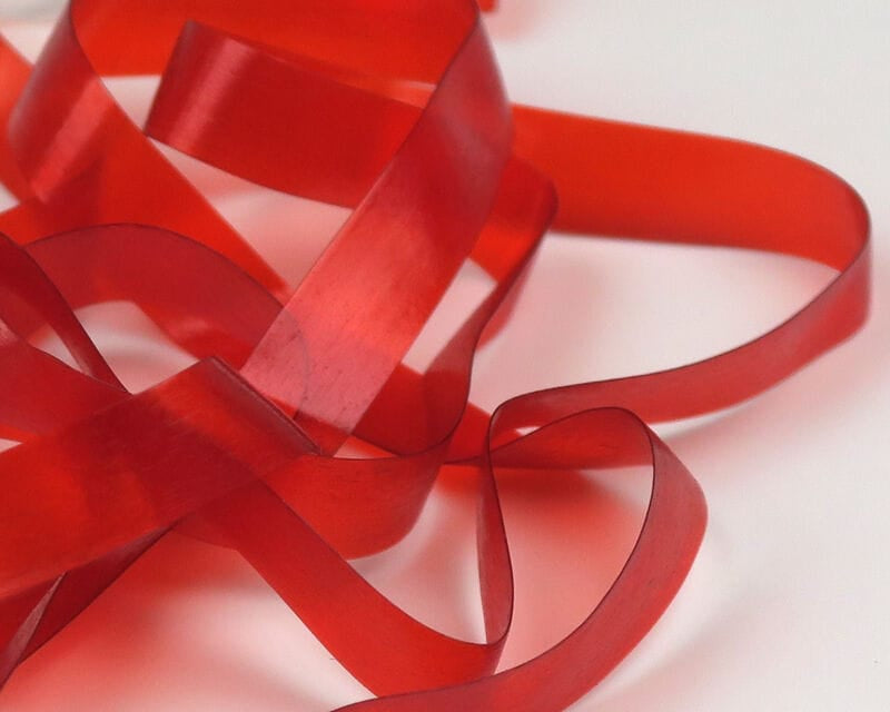 Translucent red silicone Hareline Scud Back flat ribbon strips for fly tying, flexible scud body material