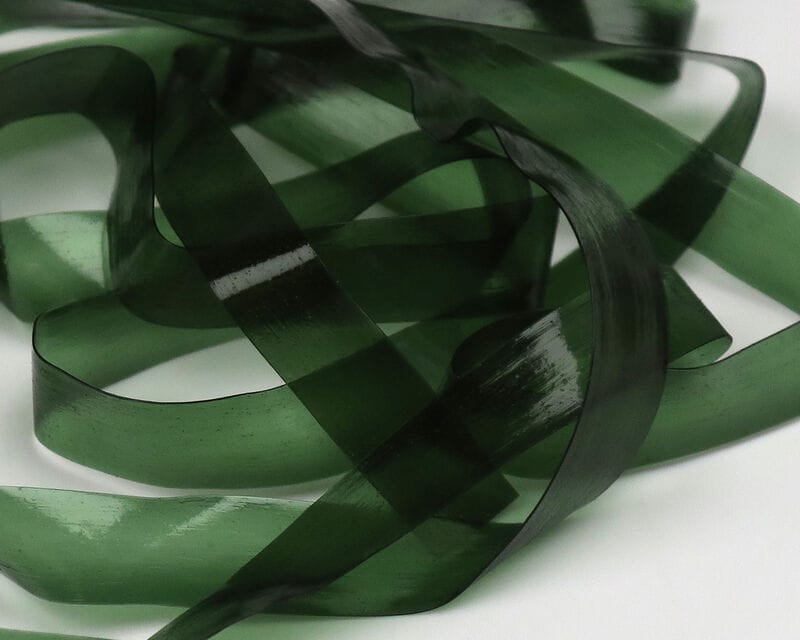 Translucent olive green Hareline Scud Back strips, glossy flexible plastic ribbon material for fly tying scud patterns.