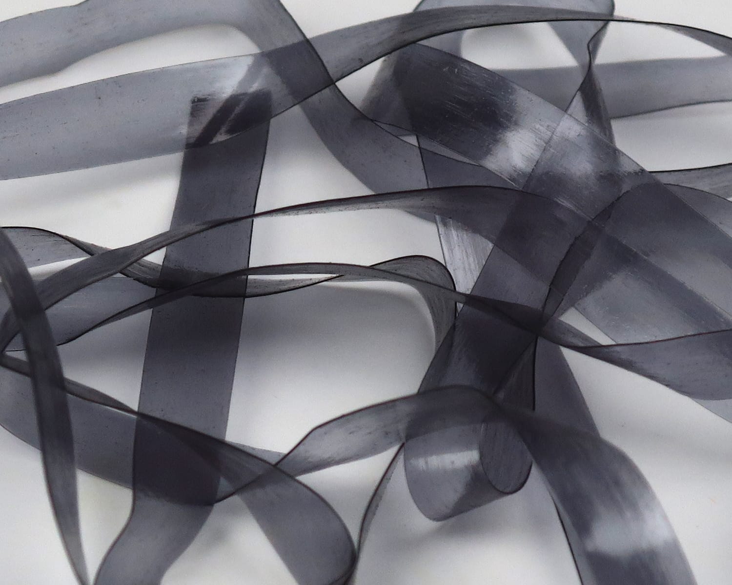 Translucent charcoal Scud Back strips, glossy flexible plastic ribbon material for fly tying
