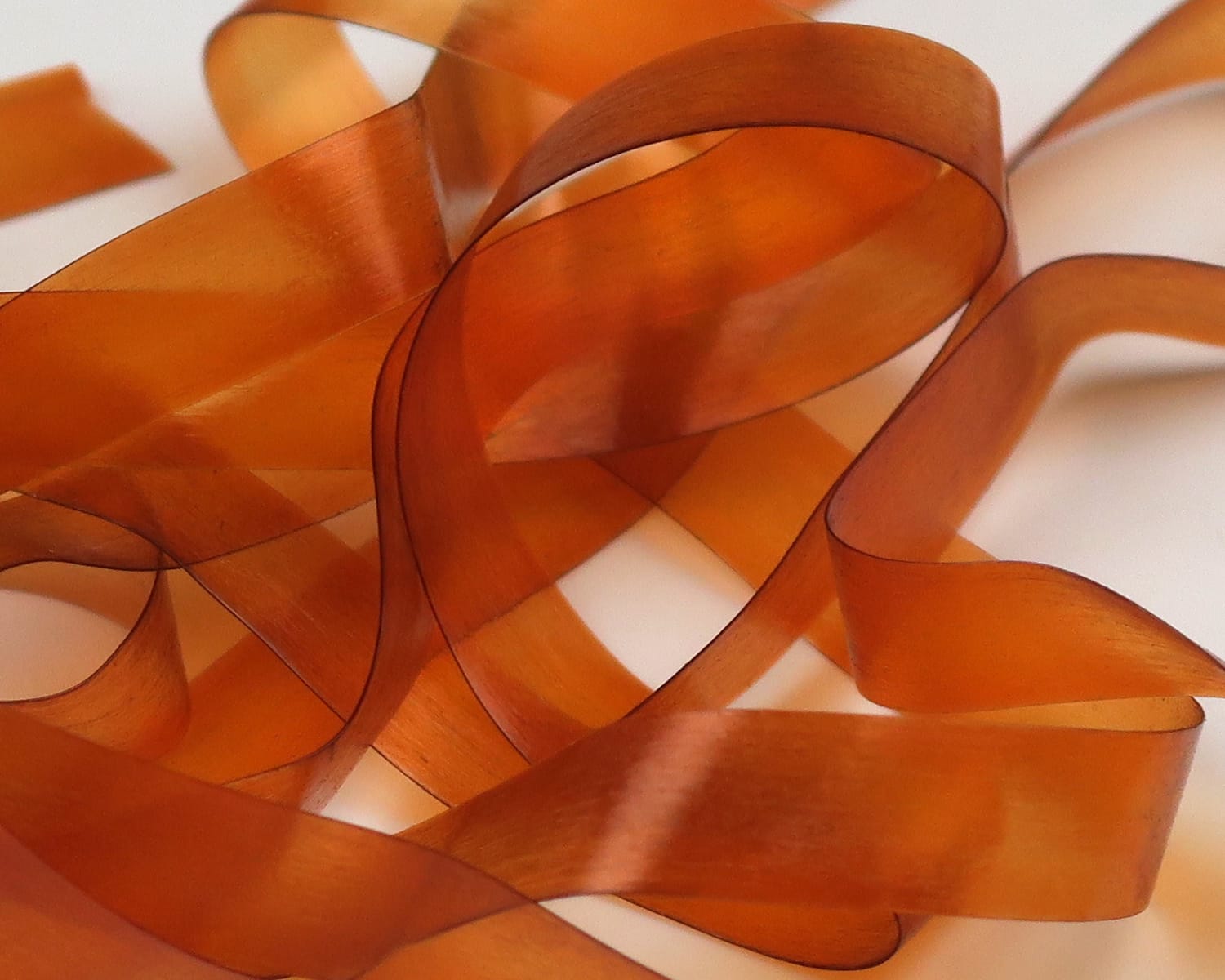 Translucent amber Hareline Scud Back strips, thin flexible plastic ribbons with matte sheen for fly tying