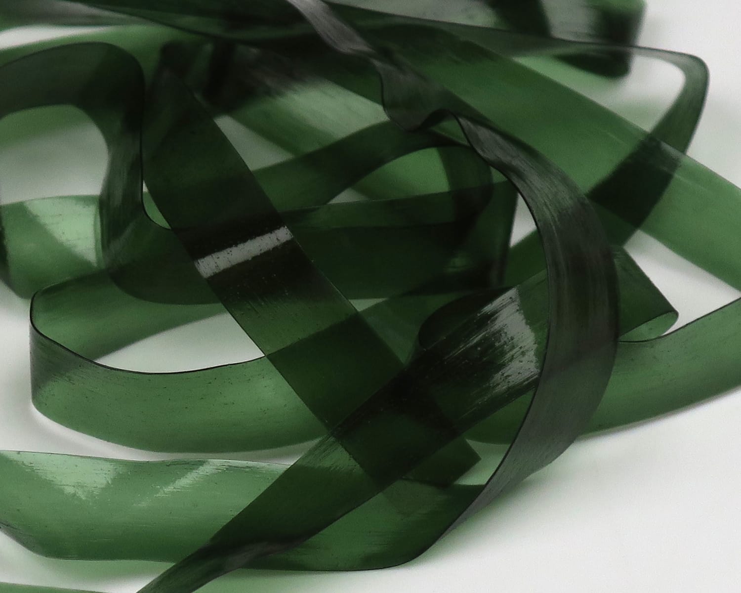 Dark green translucent Hareline Scud Back ribbons, glossy flexible plastic strips for fly tying