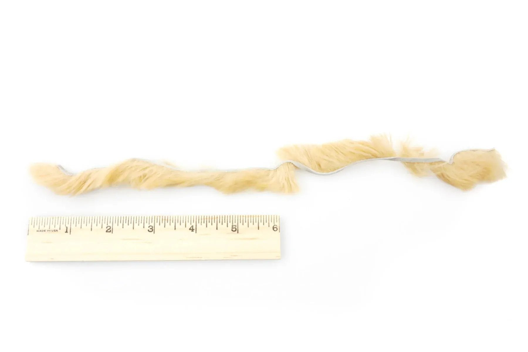Pale tan Hareline Silky Bunnybou strips for fly tying, soft fur ribbon strip laid beside ruler for scale
