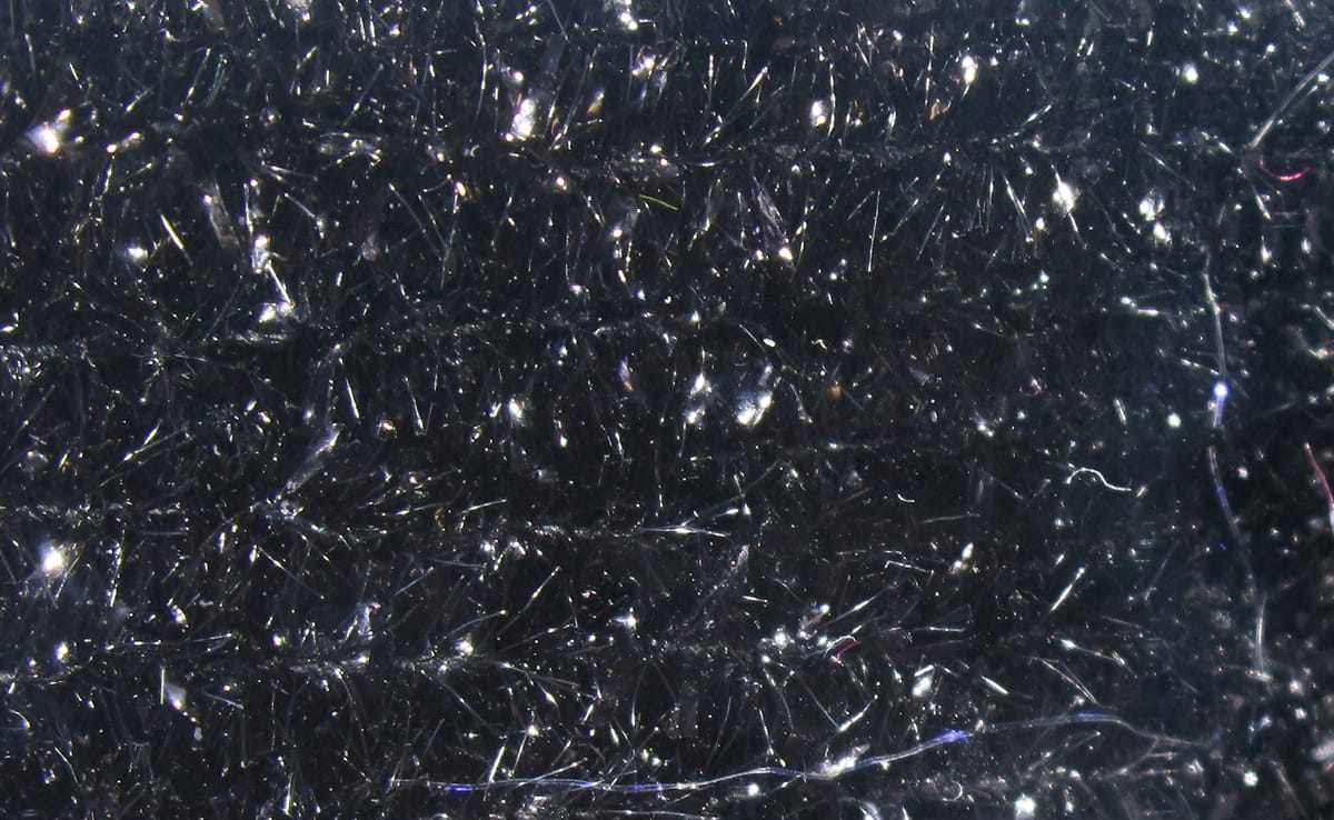 Black Hareline solid tinsel chenille with dense shimmering silver reflective fibers for fly tying