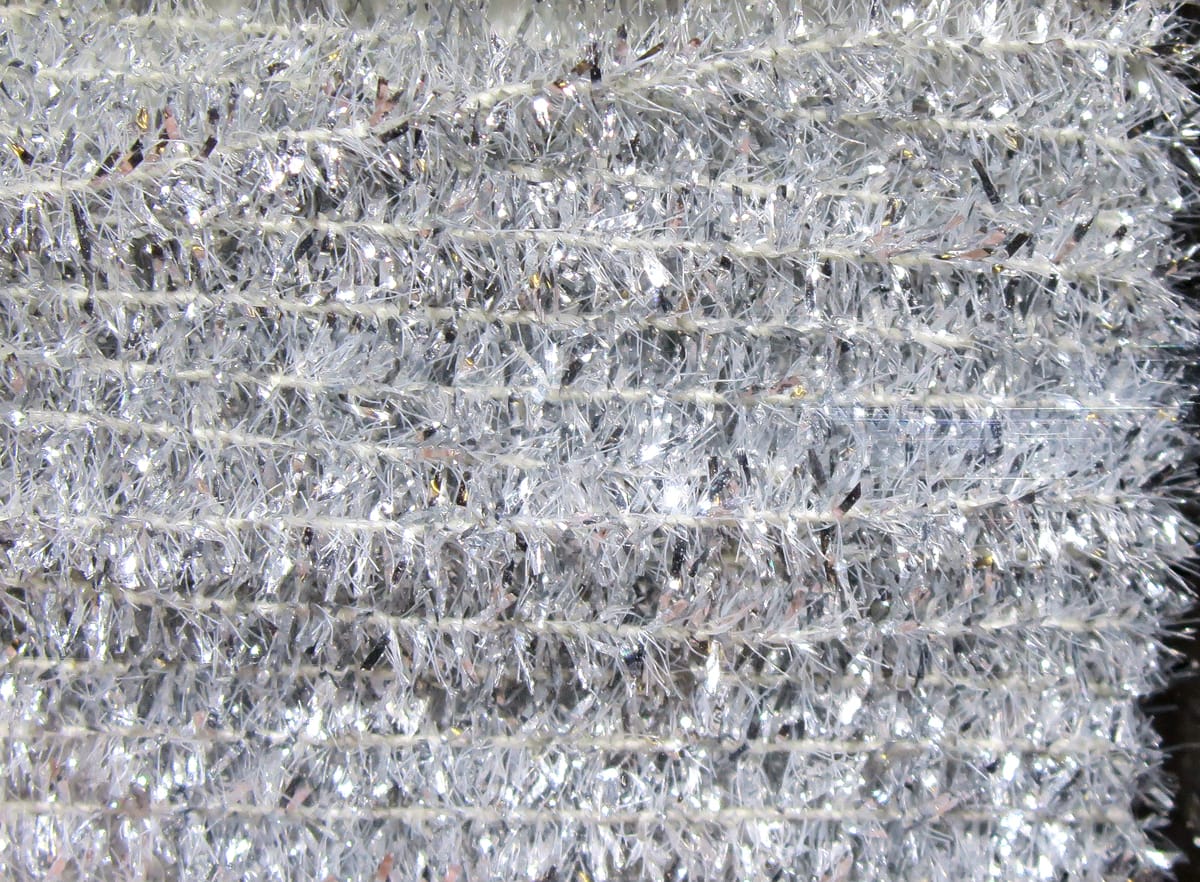 Silver Hareline solid tinsel chenille with dense metallic sparkles, fluffy strands for fly tying