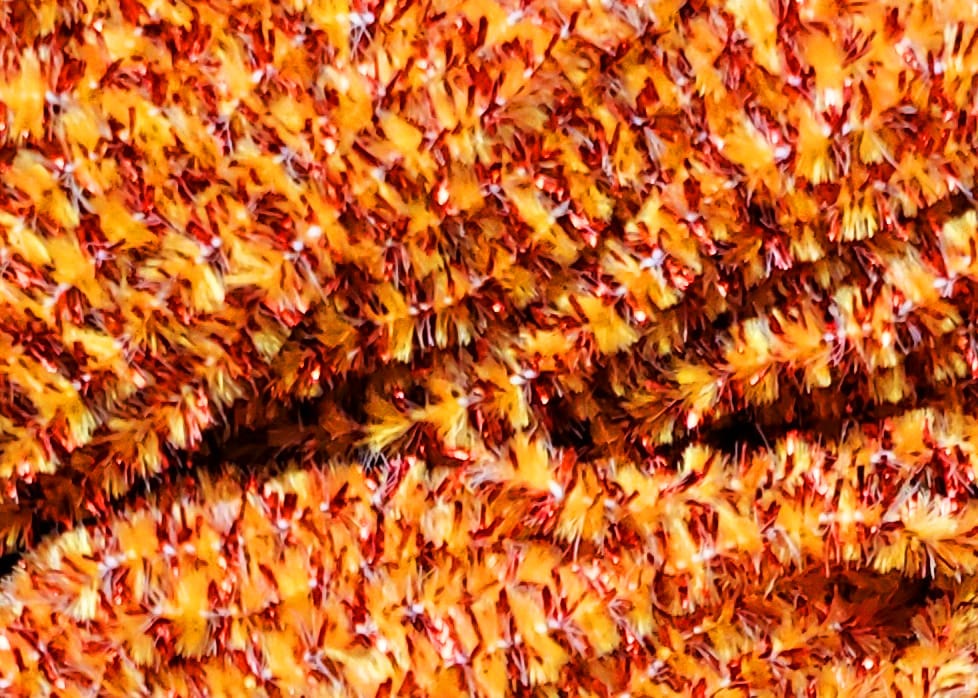 Speckled orange and yellow chenille with red metallic flecks, fuzzy textured fly tying material