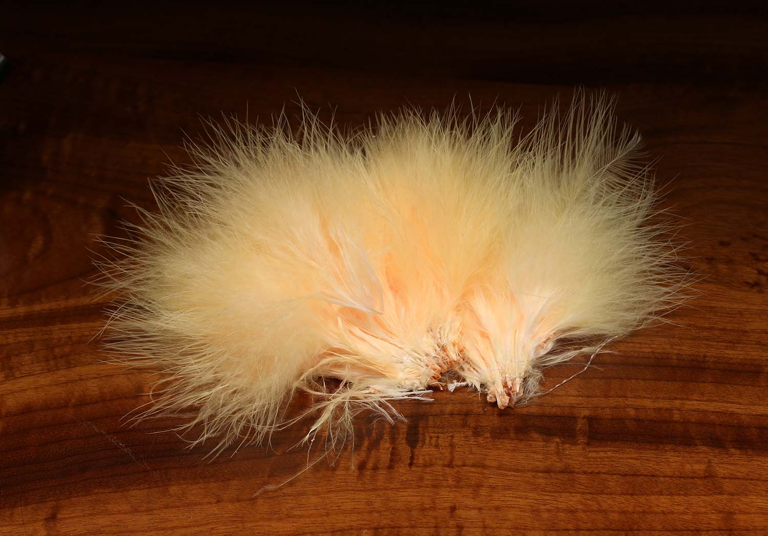 Soft pale peach marabou blood quills, fluffy strung feathers for fly tying on wooden background