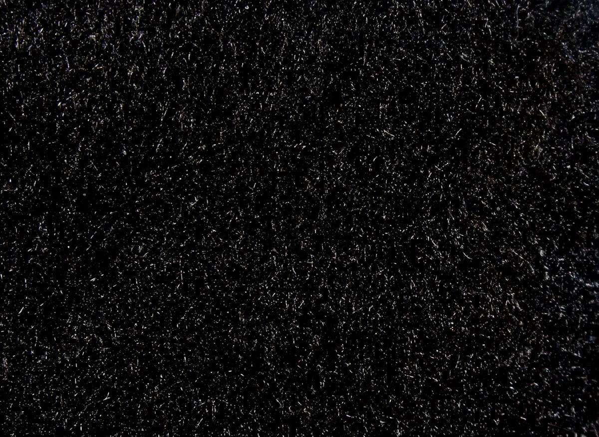 Black Hareline super fine dry fly dubbing closeup showing ultra-fine fibrous texture with subtle silver sparkle for fly tying