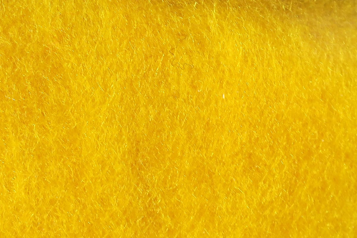 Bright canary yellow Hareline super fine dry fly dubbing close-up showing fine synthetic fibrous texture for fly tying