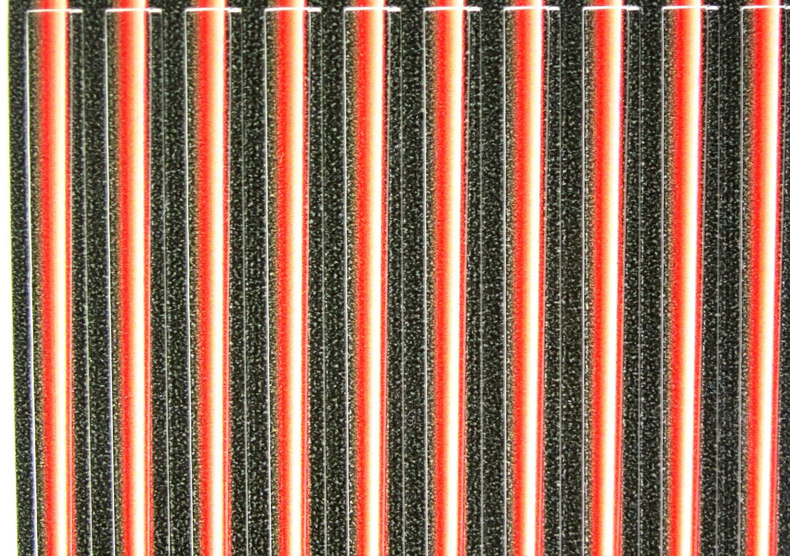Hareline tapered synthetic quills, parallel black speckled shafts with red-orange center stripe, fly-tying material