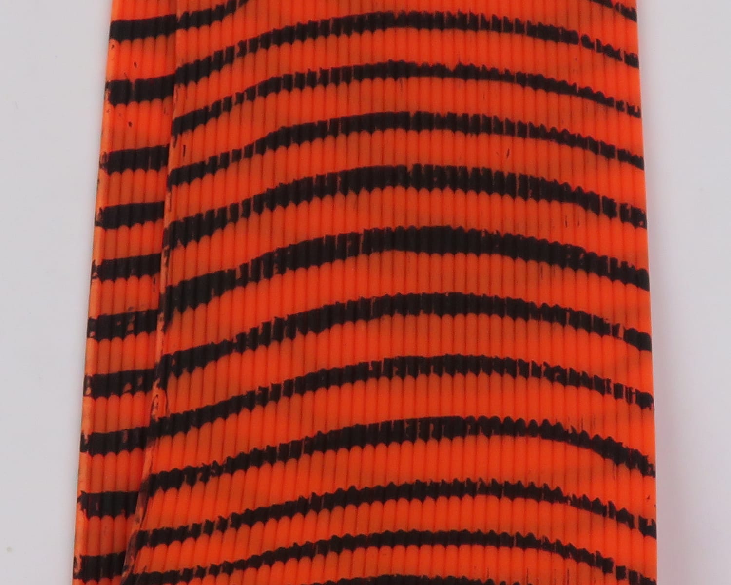 Orange ribbed synthetic Tarantu-Leggs with black tiger stripes for fly tying, Hareline