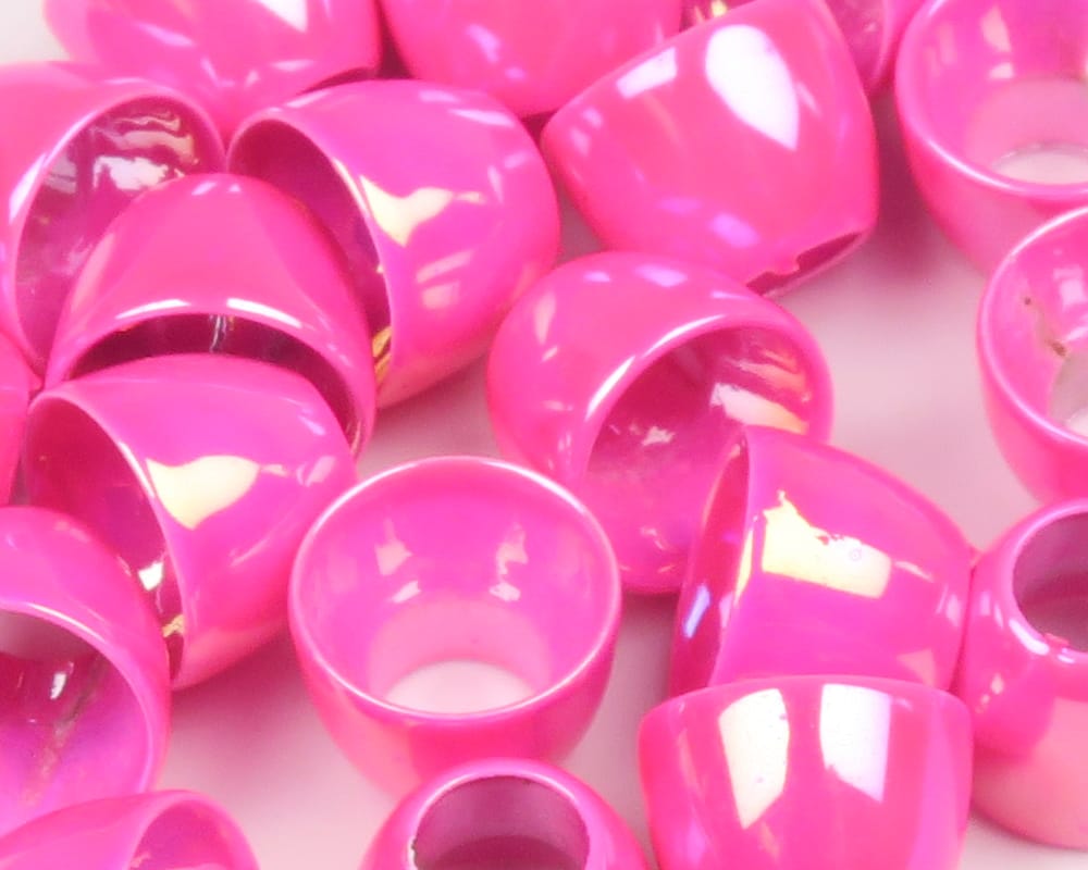 Glossy hot-pink Hareline tube cone heads for fly tying, close-up of hollow tapered cones