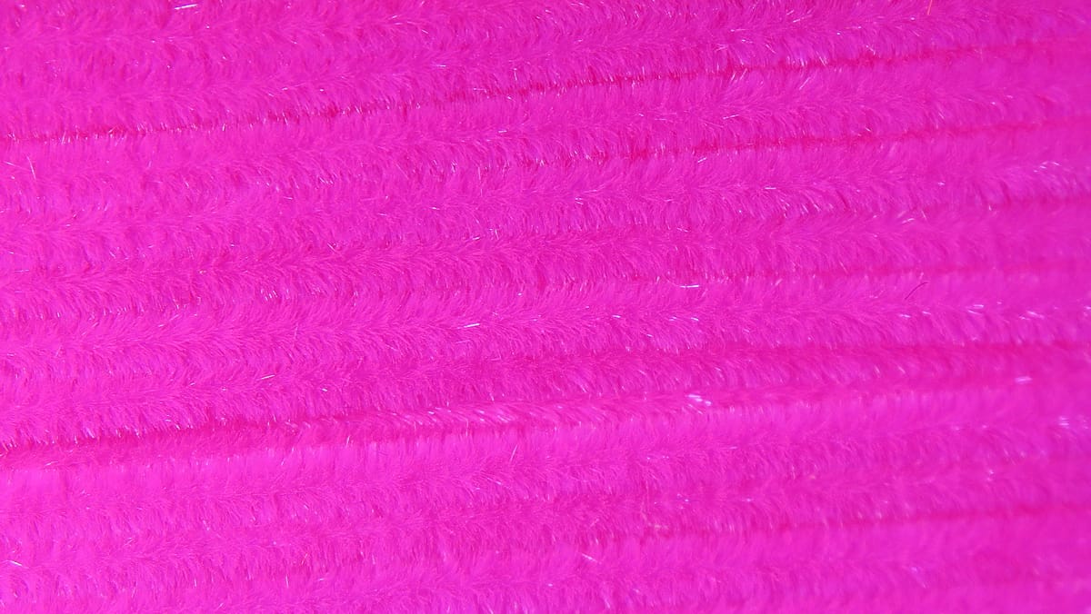 Hot pink Hareline Ultra chenille with dense fuzzy pile and subtle iridescent fibers for fly tying