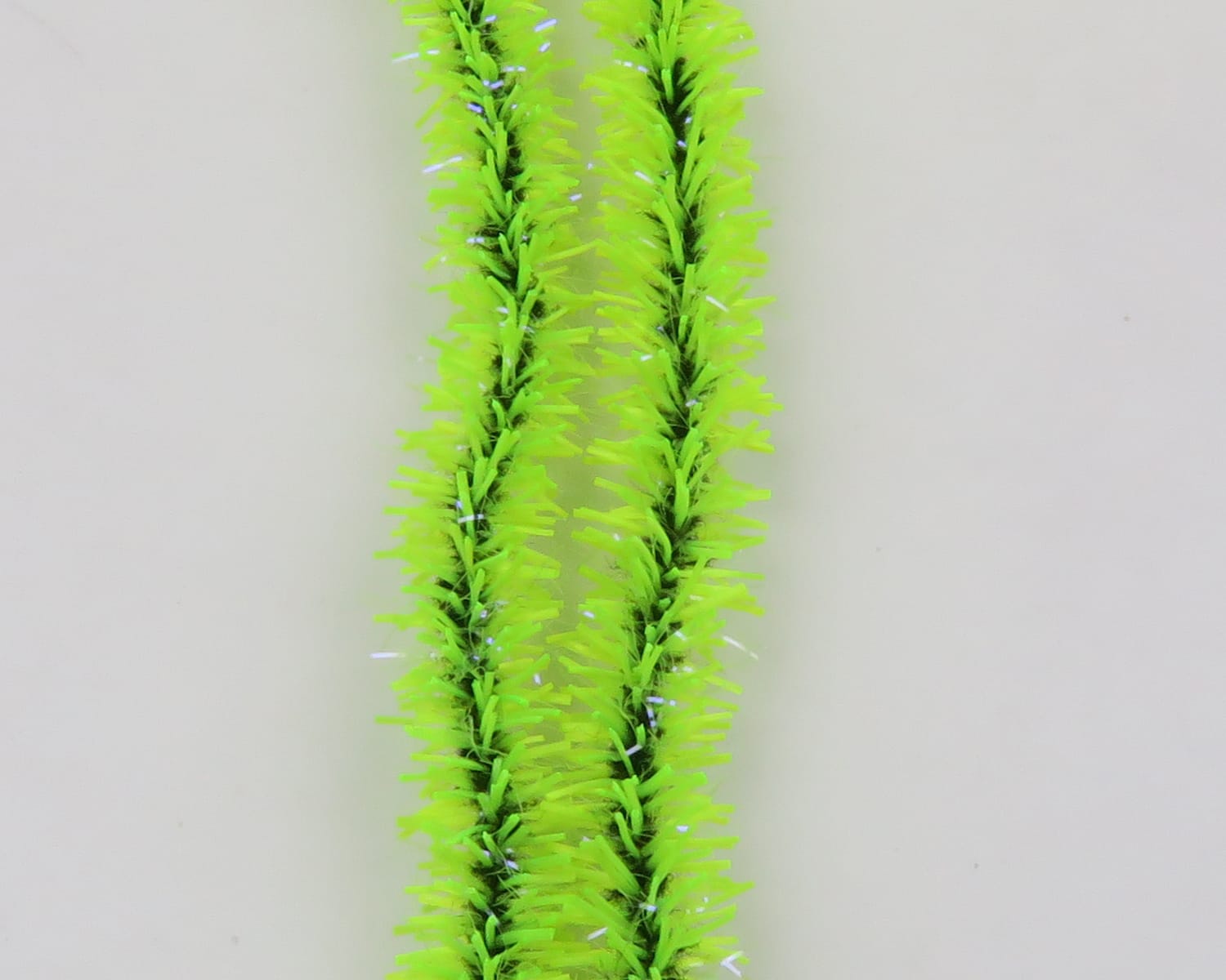 Two fluorescent chartreuse UV Badger Flexi Squishenille chenille strands with glossy tinsel fibers for fly tying