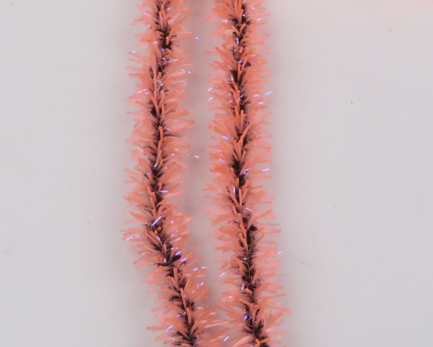 Peach UV Badger Flexi Squishenille chenille strands with dark core and iridescent tinsel for fly tying