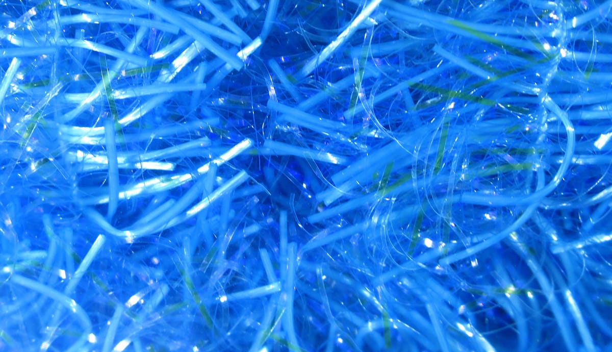 Bright electric blue UV Life Flex wrap with shiny, thin iridescent synthetic strands for fly tying