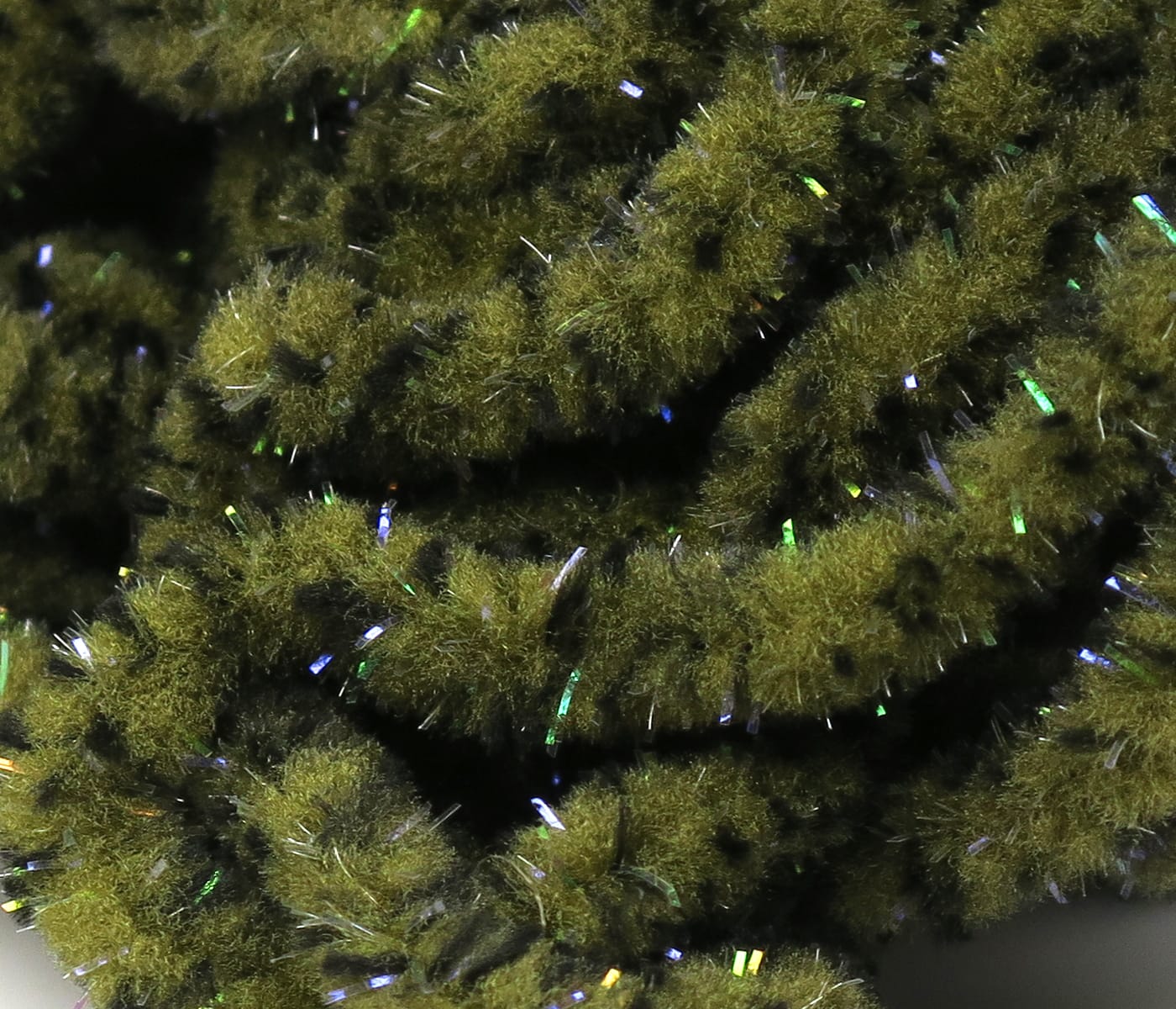 Hareline mop chenille in mottled olive green with fuzzy chenille strands and iridescent UV tinsel flashes for fly tying
