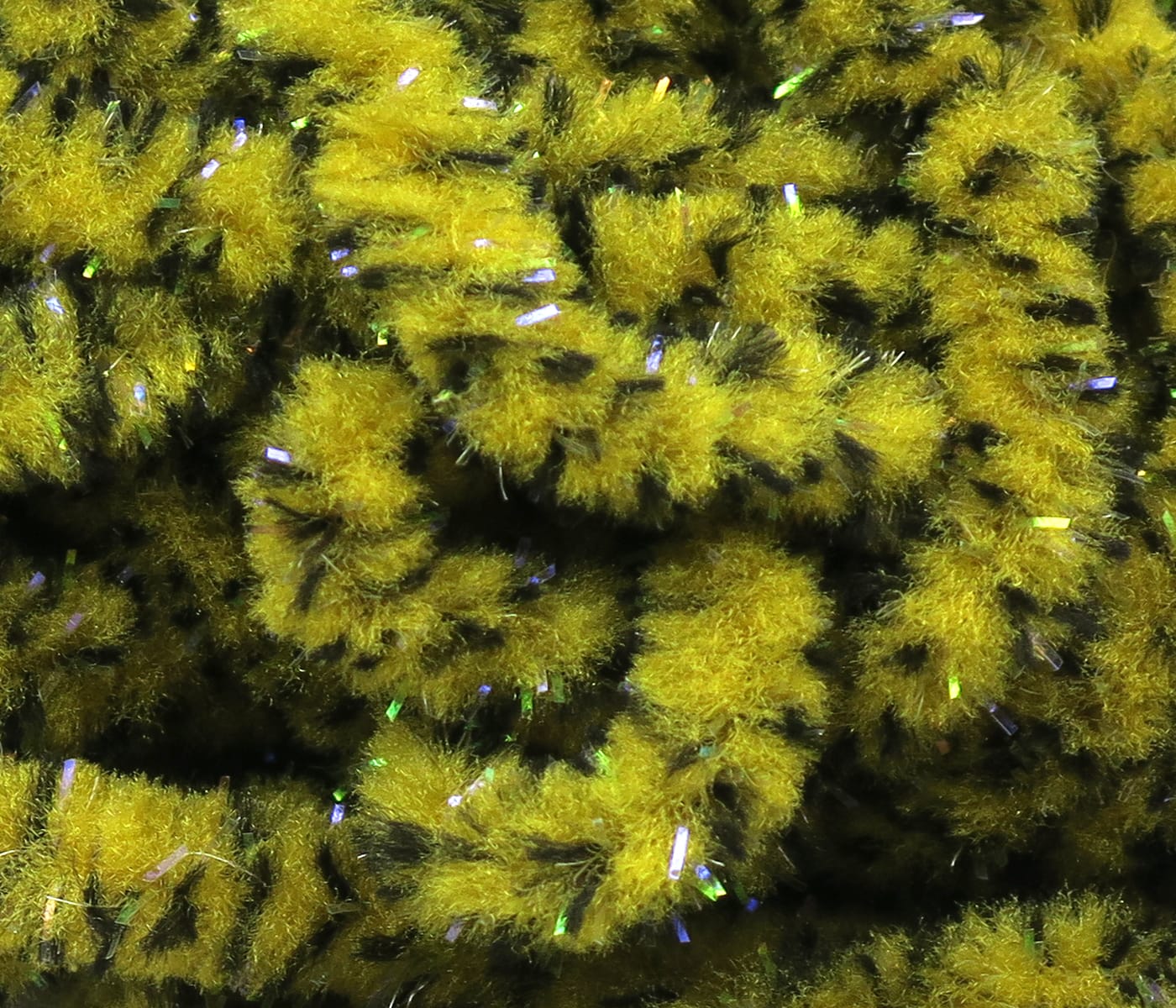 Yellow-olive mottled mop chenille with black speckles and iridescent tinsel fibers, fuzzy fly tying material
