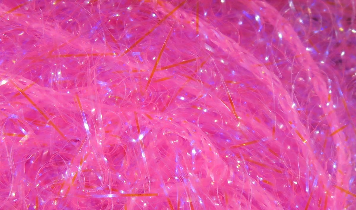 Bright pink Hareline UV polar chenille with iridescent tinsel strands, fluffy fuzzy texture for fly tying