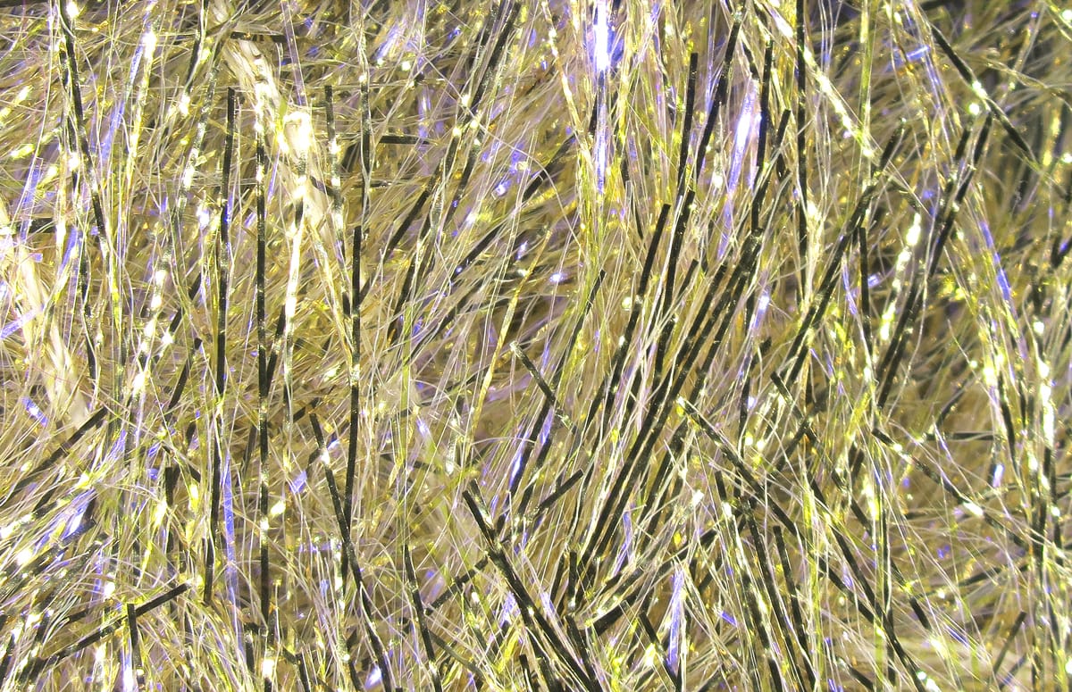 Gold iridescent Hareline UV Polar chenille clump with thin shimmering tinsel fibers and black accent strands for fly tying