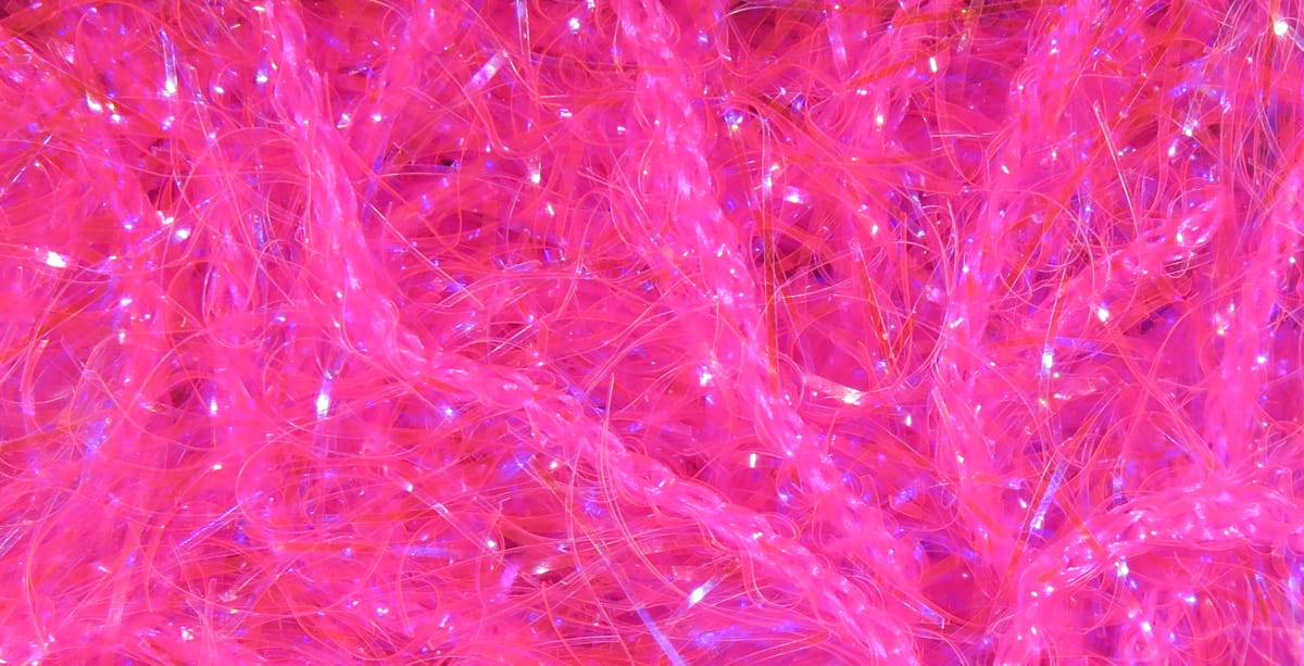 Bright neon pink Hareline UV Polar chenille with iridescent, sparkly synthetic fibers and braided fuzzy strands for fly tying