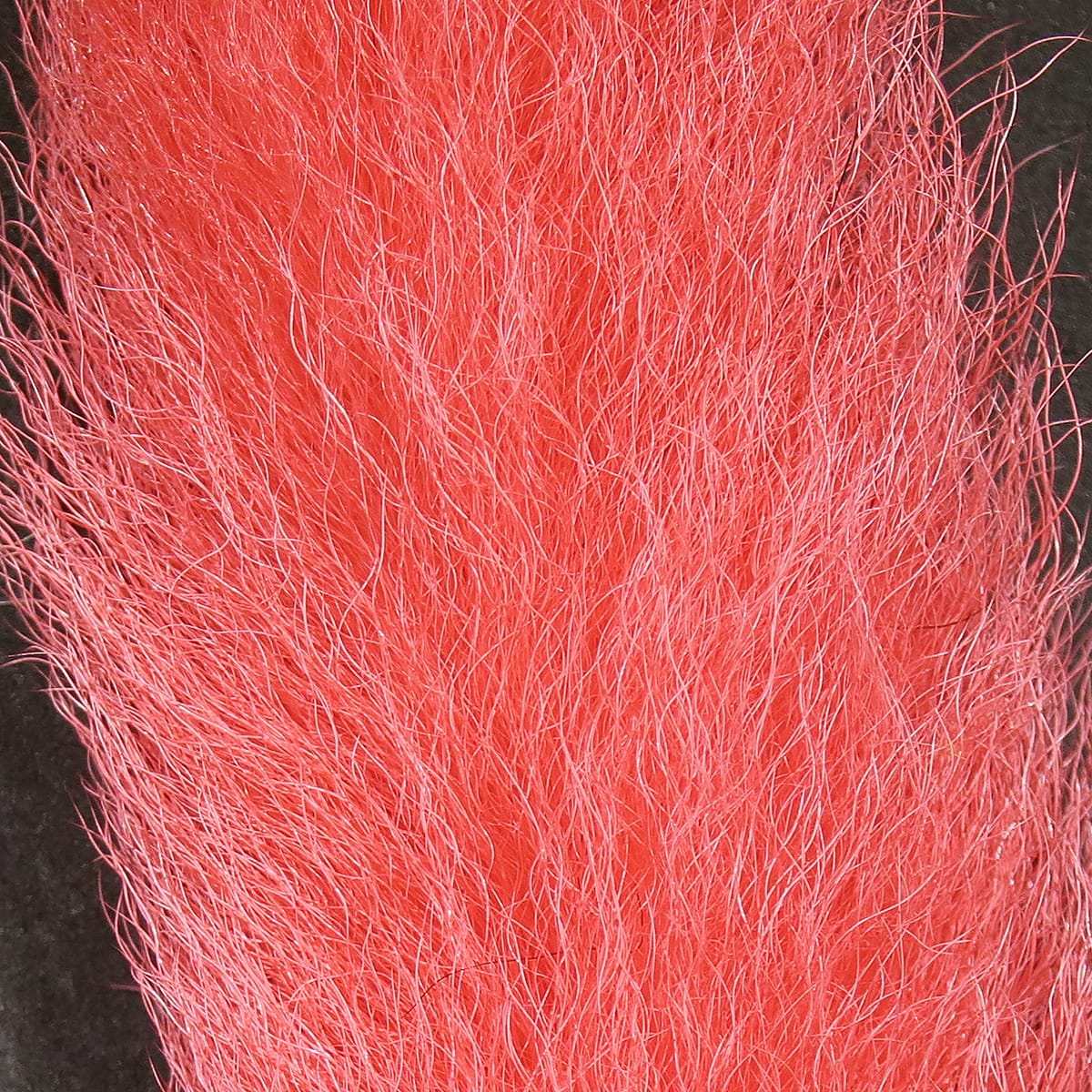 Hareline UV2 calf tail for fly tying, bright coral-pink long soft hair fibers with subtle sheen