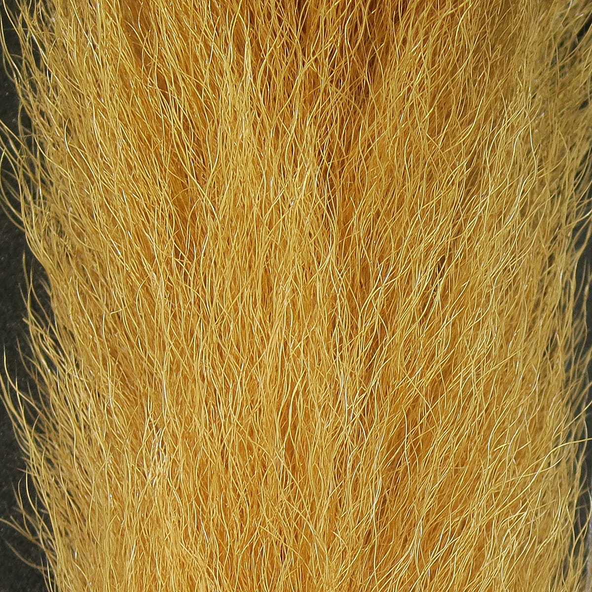 Golden tan calf tail fibers with fine, glossy strands and subtle UV sparkle for fly tying