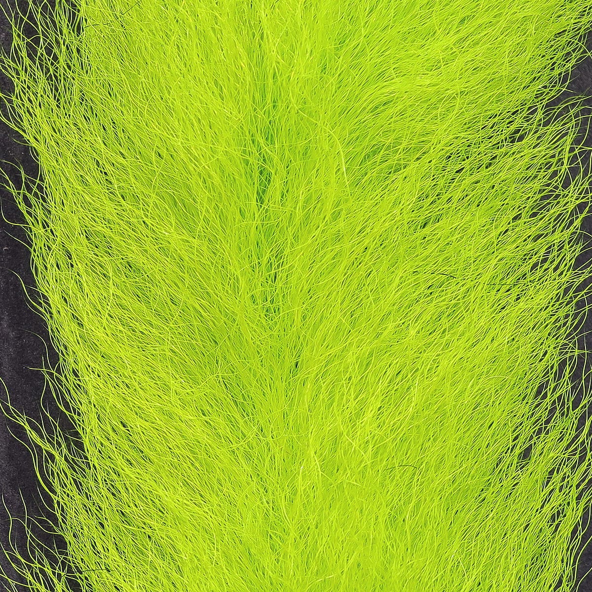 Fluorescent chartreuse UV2 calf tail, long wispy calf hair fibers for fly tying on black background