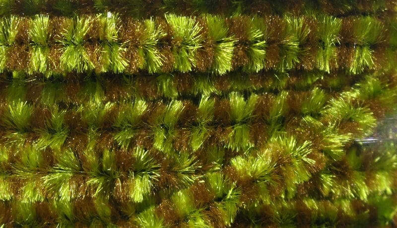 Hareline variegated chenille close-up showing green and brown iridescent fuzzy fibers with dense tufted texture