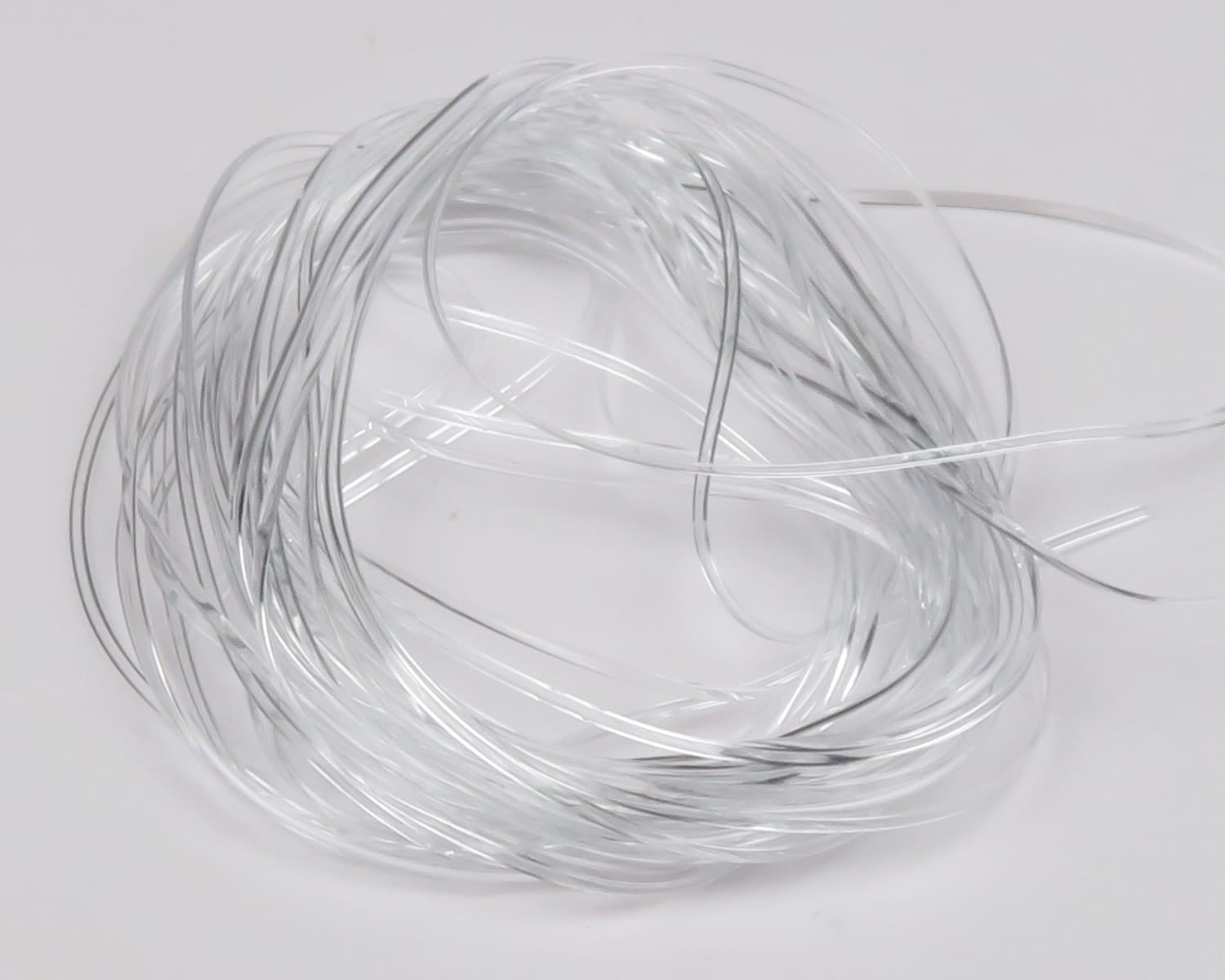 Clear translucent Hareline vinyl rib coil with fine silver metallic ribbing, flexible tubing for fly tying