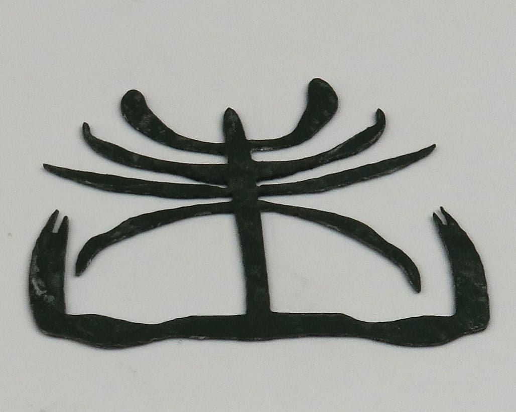 Black synthetic crab bit strips for fly tying, thin rubbery curved legs and claw shapes arranged on white background