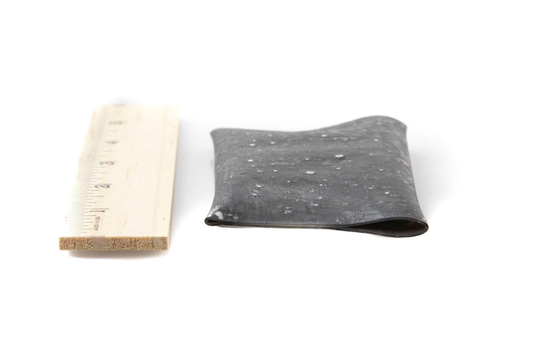 Folded dark gray speckled Exo Skin rubber sheet for fly tying beside a wooden ruler