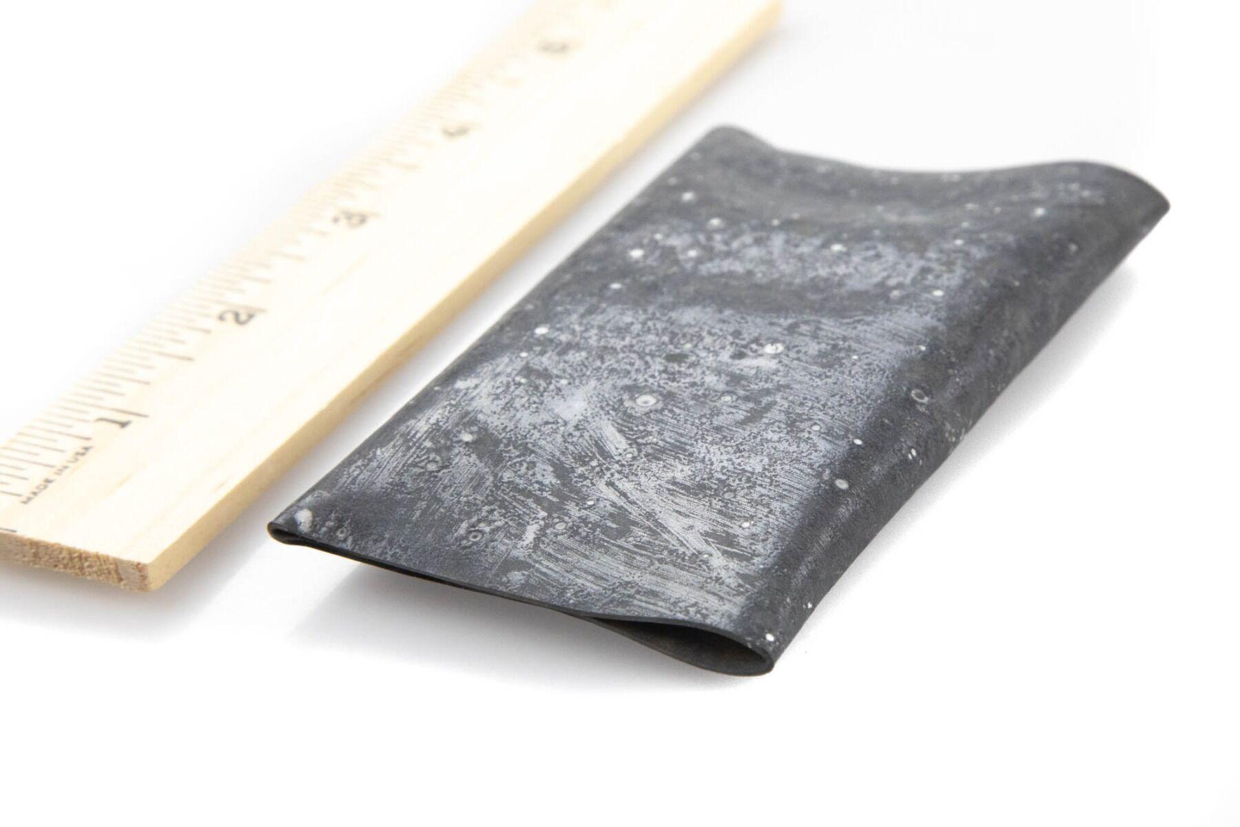 Charcoal Kiley's Exo Skin sheet with white speckled marbled texture, folded synthetic fly-tying material beside wooden ruler