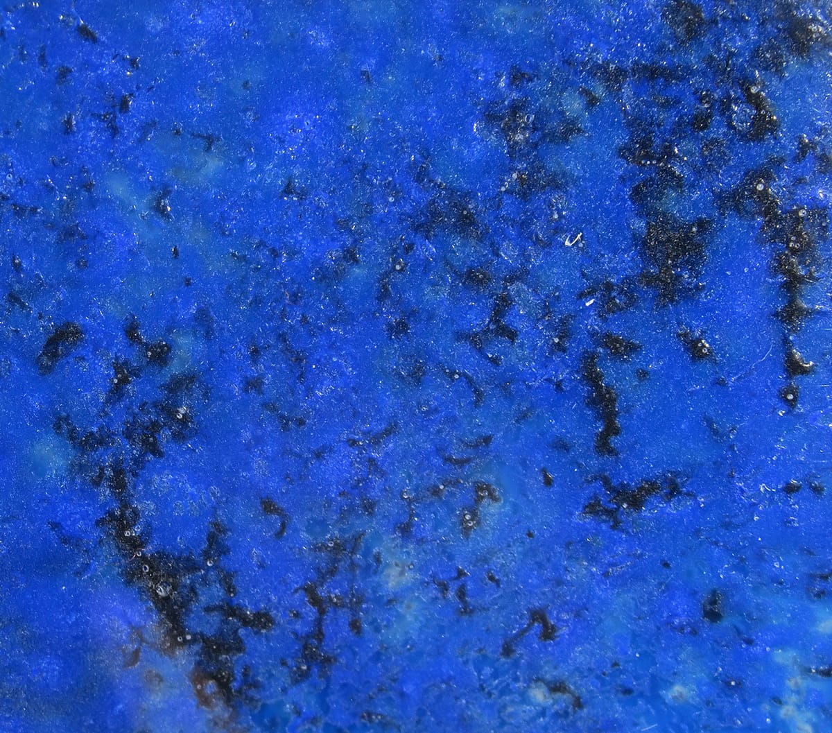 Kiley's Exo Skin synthetic fly tying material in vivid electric blue with black marbling, granular texture and subtle sparkle
