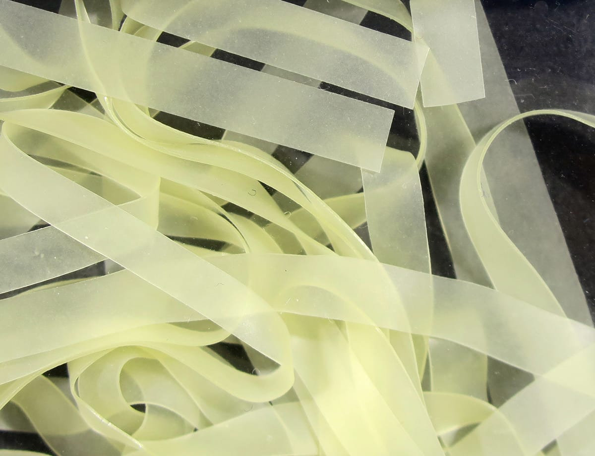 Translucent pale chartreuse nymph skins, thin soft silicone ribbon strips for fly tying, layered and coiled